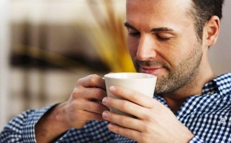 Un uomo beve un sorso di tè all'epilobio per aumentare la potenza